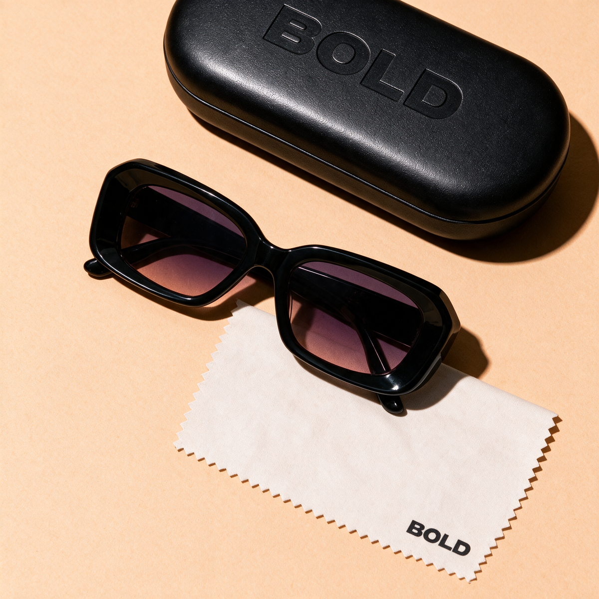 PRISM sunglasses in CARBON, flat lay with case and cloth